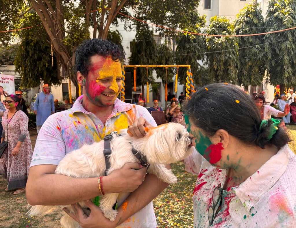A woman pets a dog who took part in Holi festivities at a park in New Delhi. Photo: AP