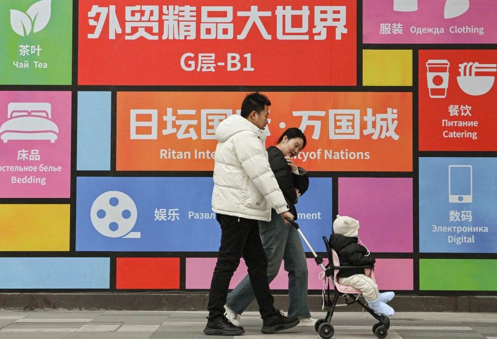 A family walks past a shopping centre in Beijing. Photo: AFP