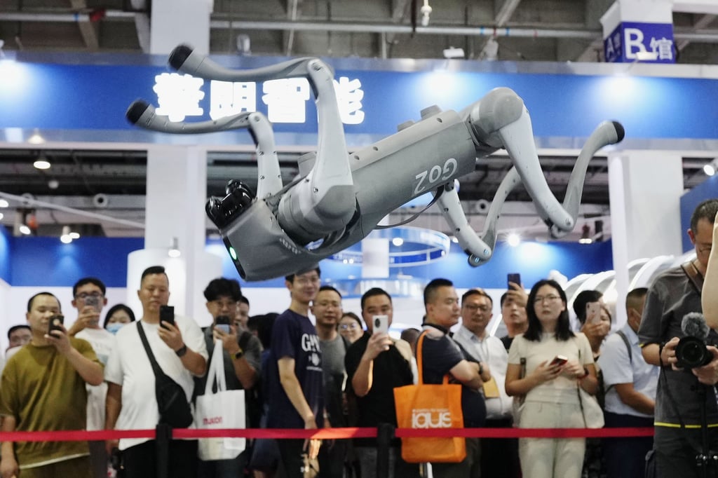 Crowds watch a robot perform a somersault at an exhibition in Beijing. Photo: Kyodo