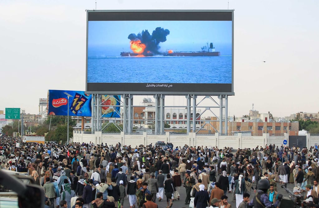 Images of a fireball exploding on a cargo ship are shown on a giant screen in Sanaa, Yemen. Photo: AFP