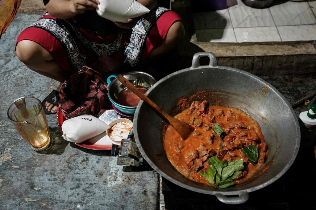 A woman cooks rendang, an Indonesian meat dish simmered in coconut milk and spices, for her family in Banda Aceh. Photo: AFP
