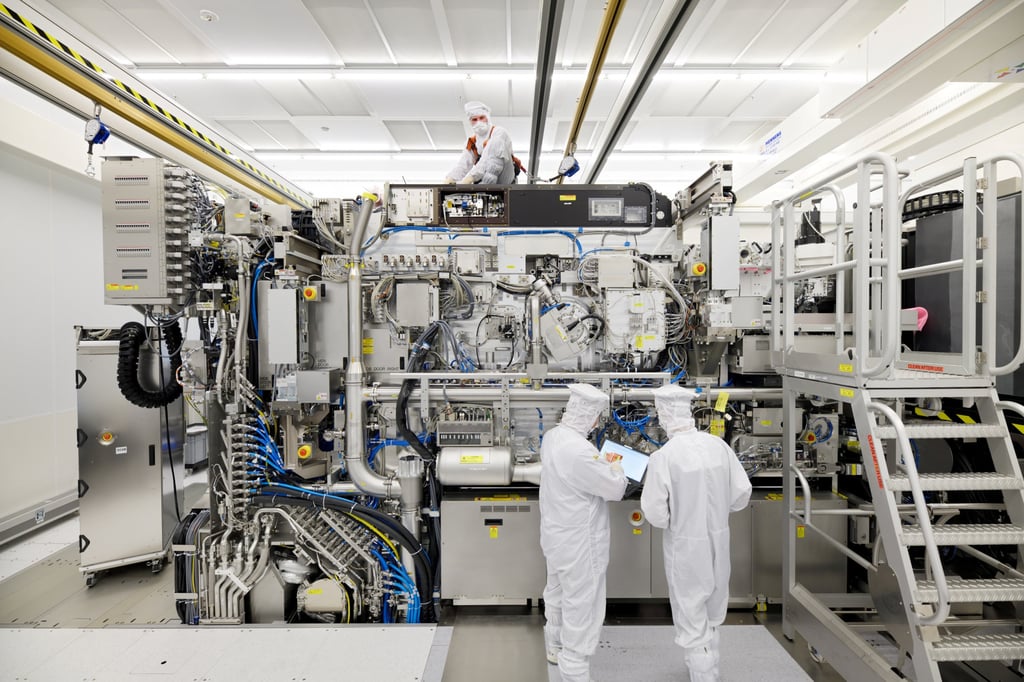 Employees are seen working on the final assembly of ASML’s TWINSCAN NXE:3400B semiconductor lithography equipment, with its panels removed, at the company’s headquarters in Veldhoven, the Netherlands. Photo: Reuters