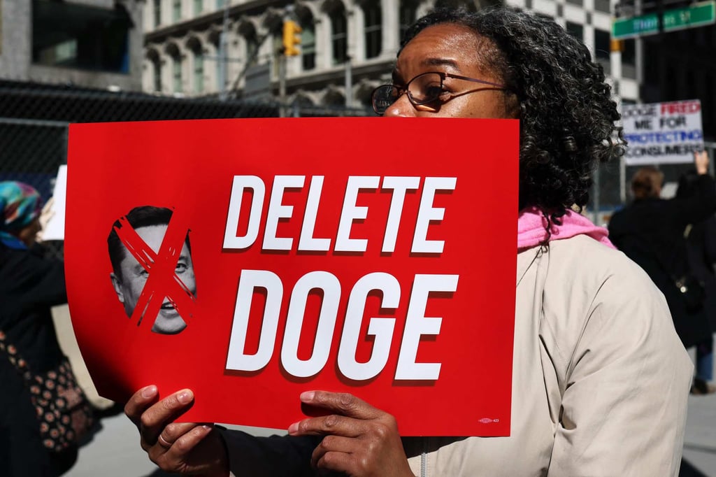 A person holds a sign during an “informational picket” over Doge’s reductions to the federal workforce in New York on March 19. Photo: AFP