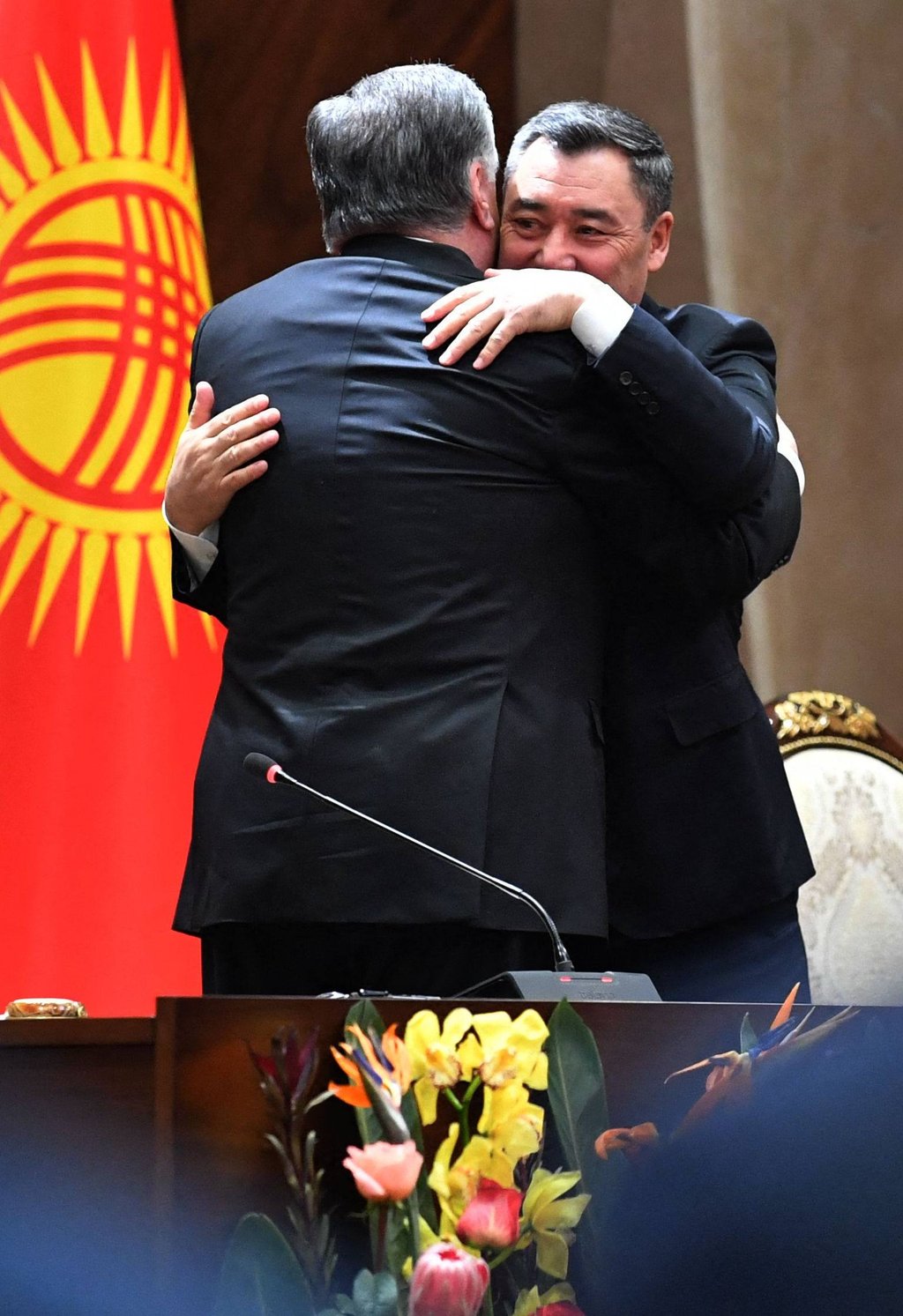 Kyrgyz President Sadyr Japarov (facing camera) and his Tajik counterpart Emomali Rahmon hug at the end of a joint press conference following their talks in Bishkek on March 13. Photo: AFP