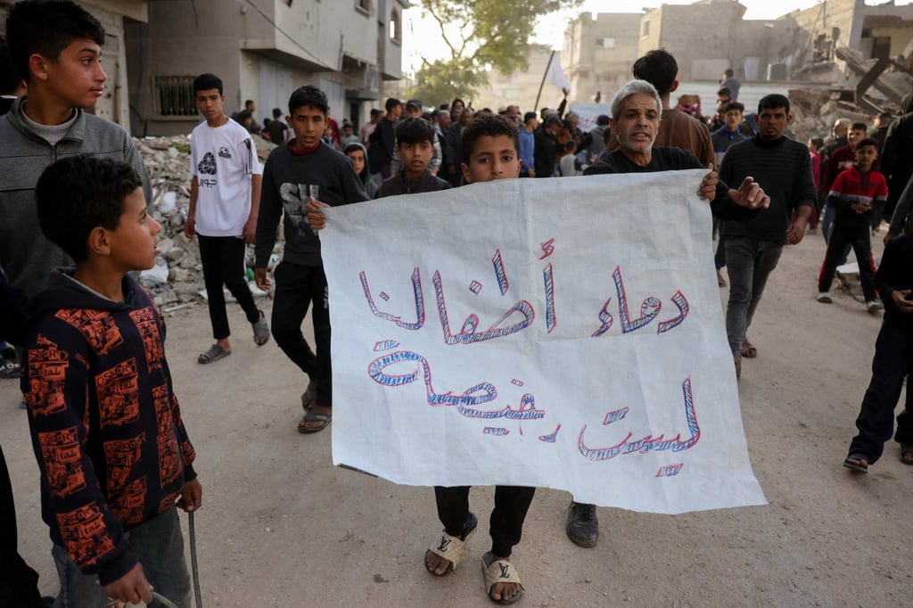 A sign in Arabic reads: ‘The blood of our children is not cheap’. Photo: AFP