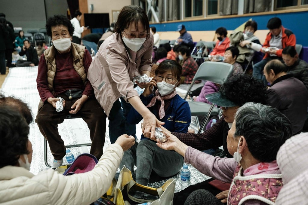 People evacuated from their homes due to the approaching wildfire receive food at an evacuation centre in Andong, South Korea, on Tuesday. Photo: AFP