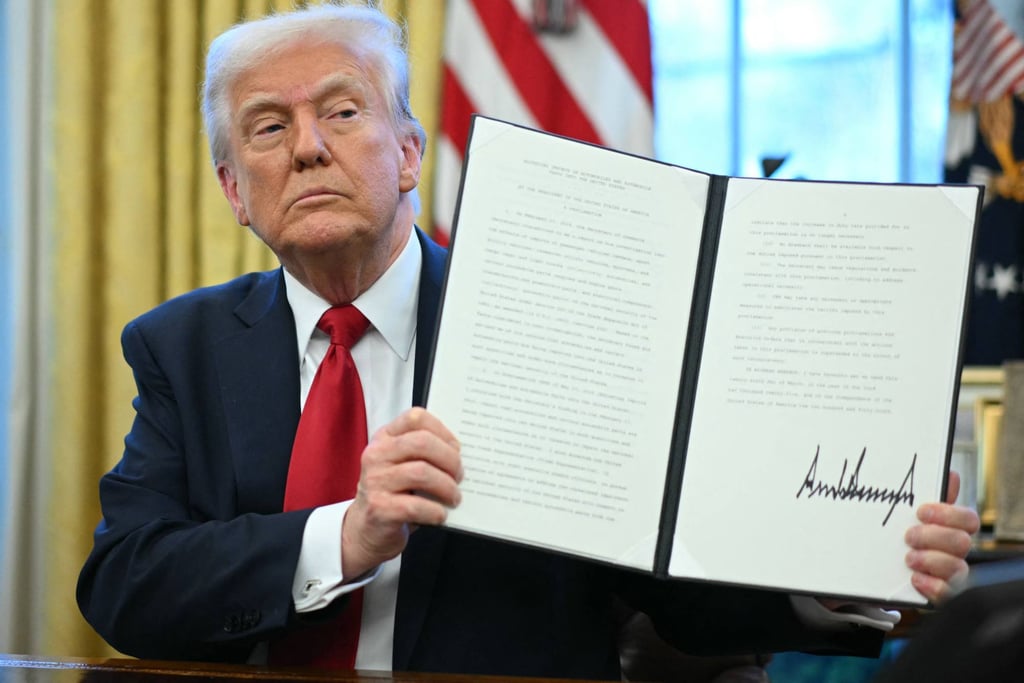US President Donald Trump displays an executive order he signed announcing tariffs on car imports in the White House on Wednesday. Photo: AFP