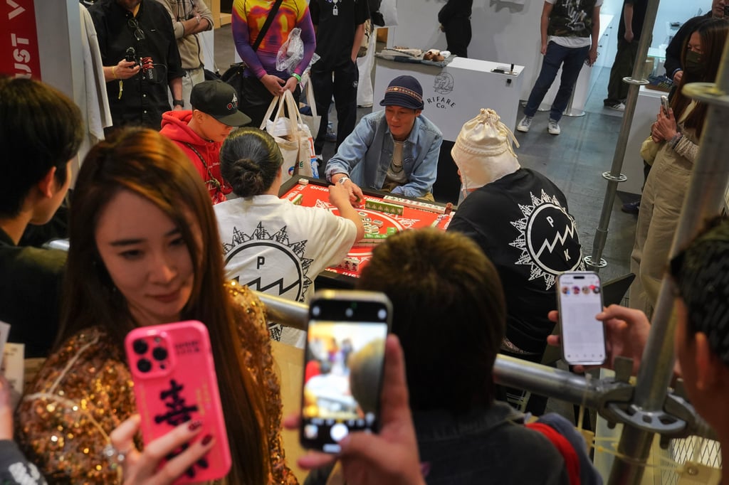 Hong Kong celebrity Edison Chen (background, in a blue hat) plays mahjong in a booth at ComplexCon. Photo: Elson Li