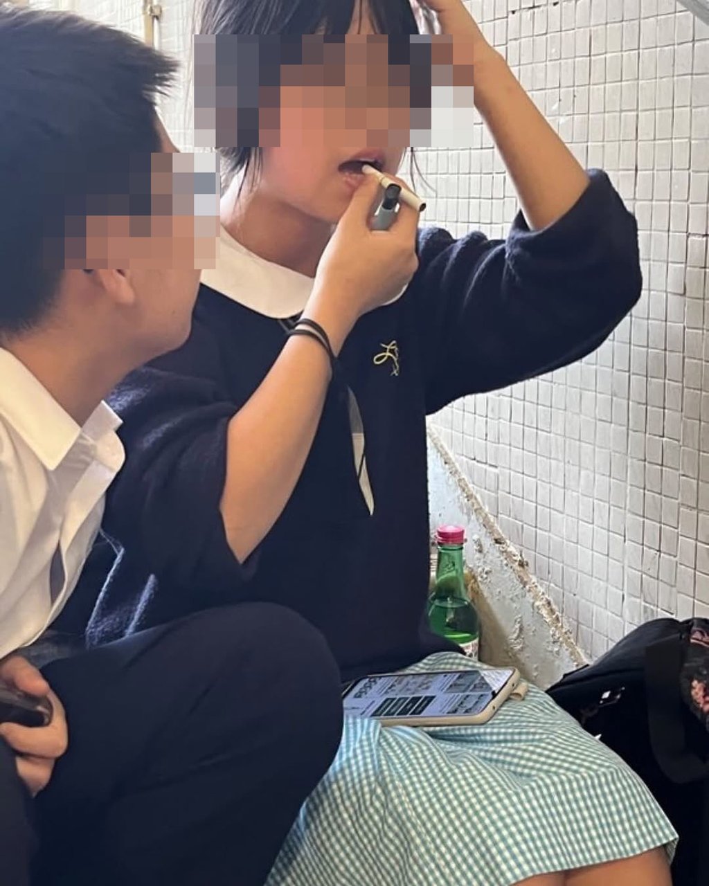 A girl, dressed in a school uniform, is seen smoking in a stairwell. Photo: Handout
