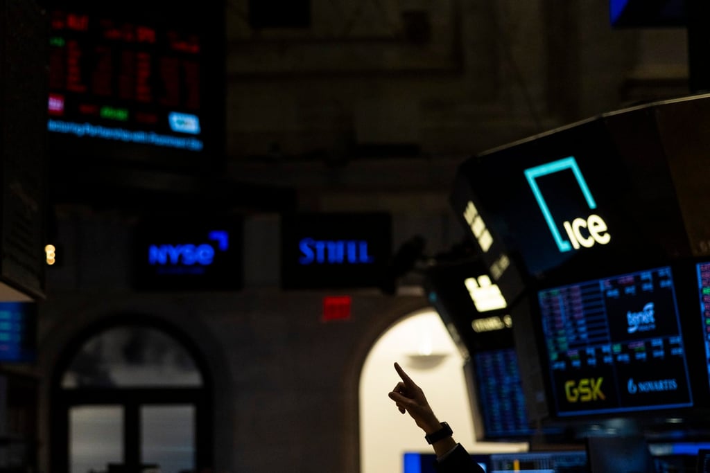 A person points to a screen showing the Dow Jones Industrial Average on the floor at the New York Stock Exchange on Thursday. The latest salvo in Donald Trump’s trade war added to volatility that’s been gripping global financial markets since the president announced the harshest tariffs in a century. Photo: EPA-EFE