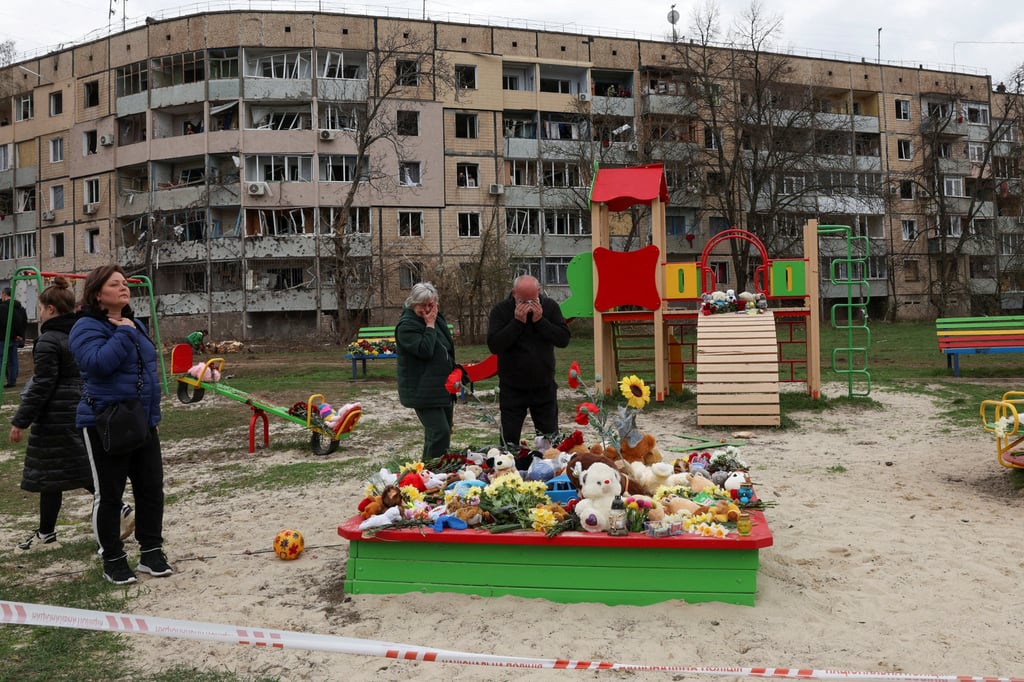 People mourn in a playground at the site of a deadly Russian missile strike on a residential area where multiple children and adults were killed, in Kryvyi Rih, Ukraine, on Saturday. Photo: Reuters
