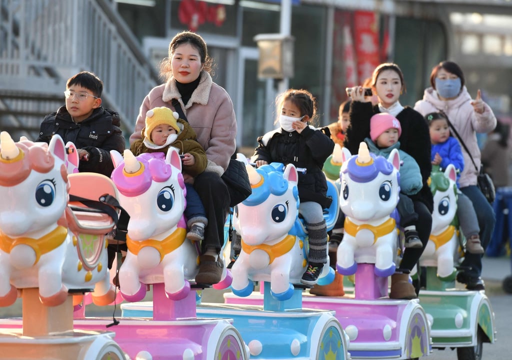 Children take a ride with adults at a park in Fuyang, Anhui province. Nearly one third of Chinese children aged over seven could be overweight or obese by 2030, according to the National Health Commission. Photo: AFP