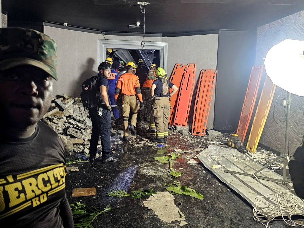 Civil defence crews and firefighters inspect the Jet Set nightclub after the collapse of its roof on Tuesday. Photo: Prensa Servicio 911/AFP