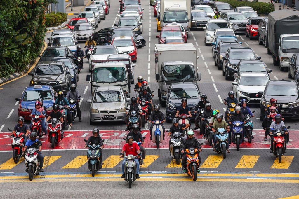 Commuters wait at a traffic light in Kuala Lumpur. Economists have lowered their growth forecasts for Malaysia this year. Photo: EPA-EFE