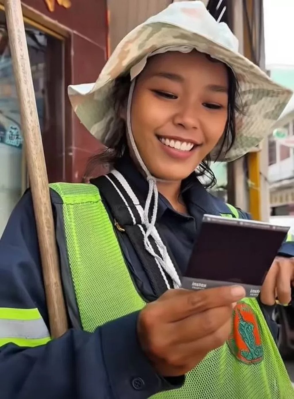 Street cleaner Meen checks out one of the photos the Russian photographer took of her. Photo: Handout