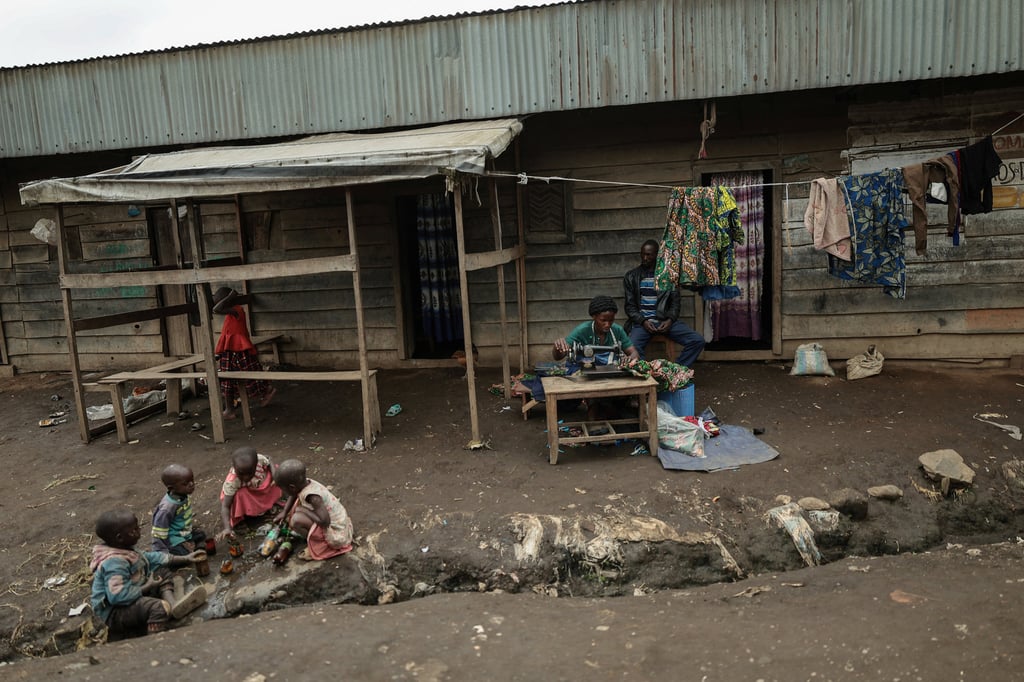 A woman sews while children play in Rubaya – controlled by M23 rebels – in eastern Democratic Republic of Congo in March. Photo: Reuters