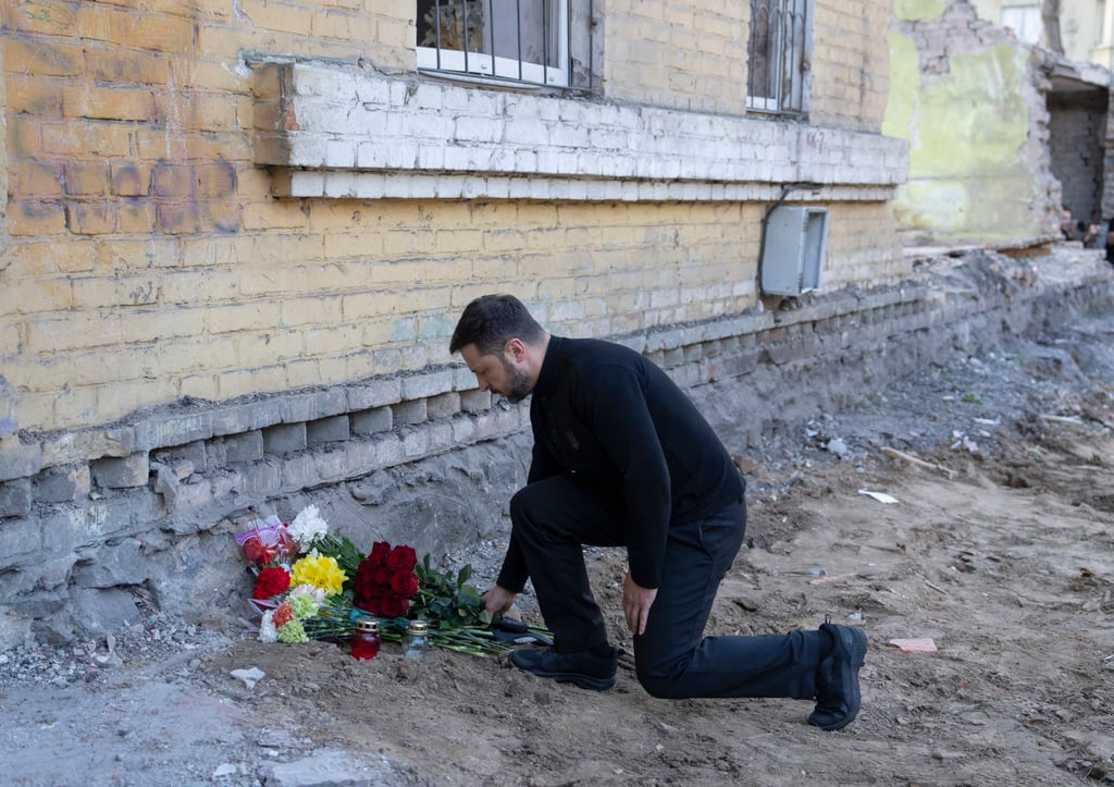 Ukrainian President Volodymyr Zelensky lays flowers at the site of a Russian missile strike on a residential area in Kyiv, Ukraine, on Friday. Photo: EPA-EFE