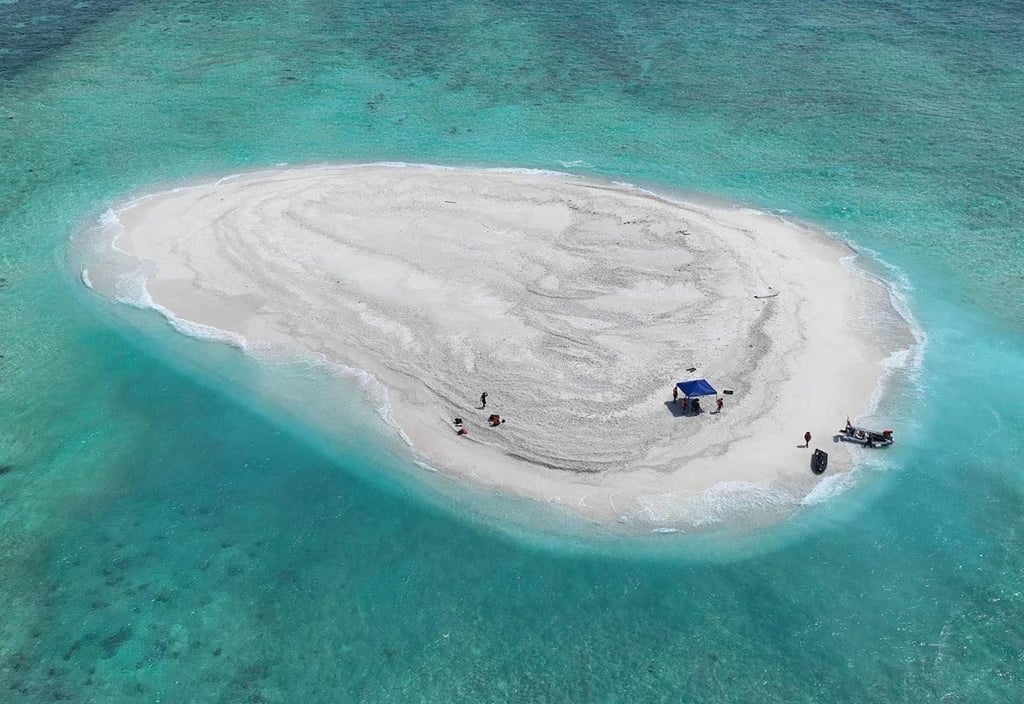 An aerial view of Philippine scientists inspecting Sandy Cay reef. Photo: AFP / Philippine Coast Guard