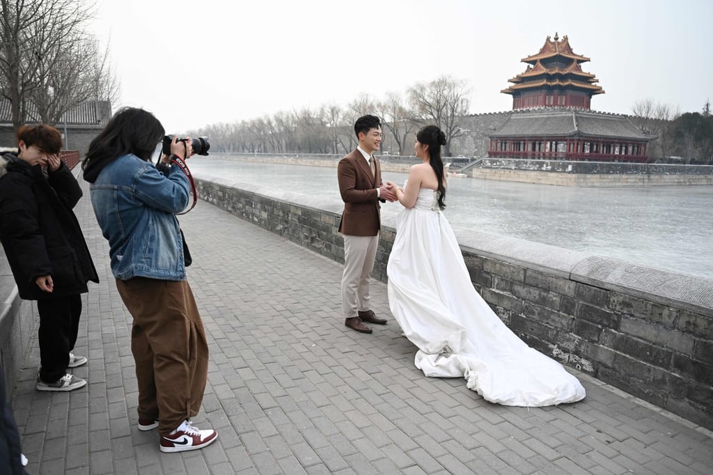 A couple poses for wedding photos outside the Forbidden City in Beijing in February 2025. Photo: AFP