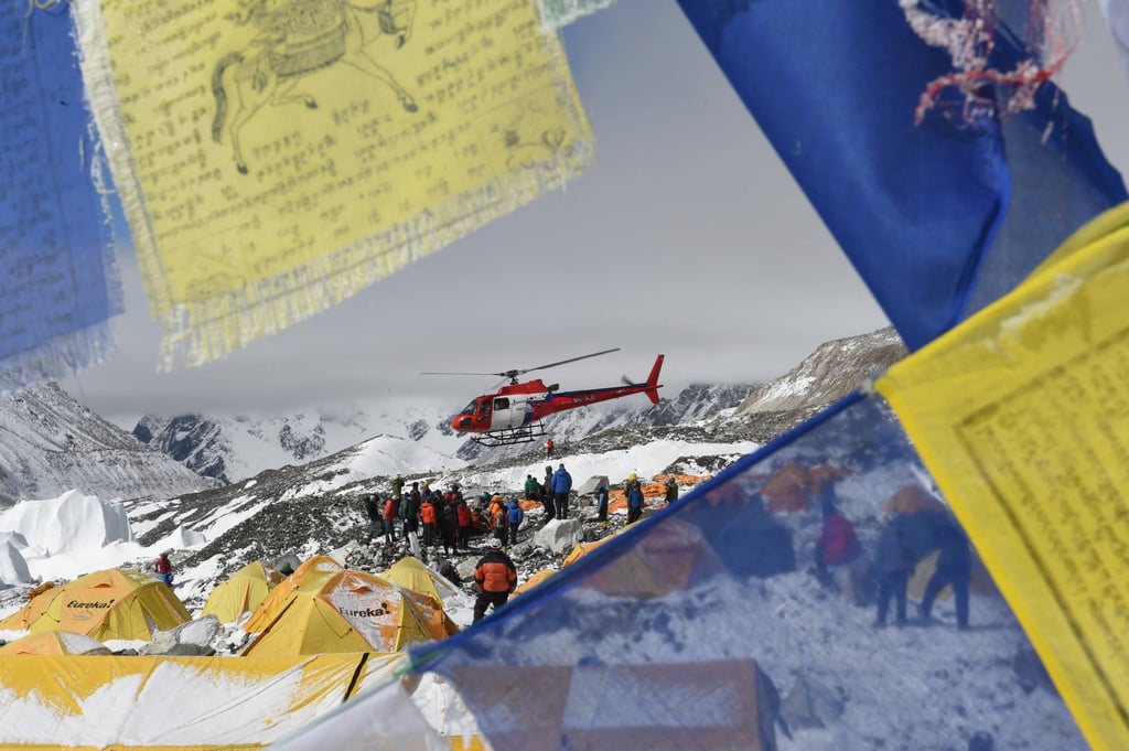 Prayer flags frame a rescue helicopter as it transport injured people from Everest Base Camp in Nepal. Photo: AFP