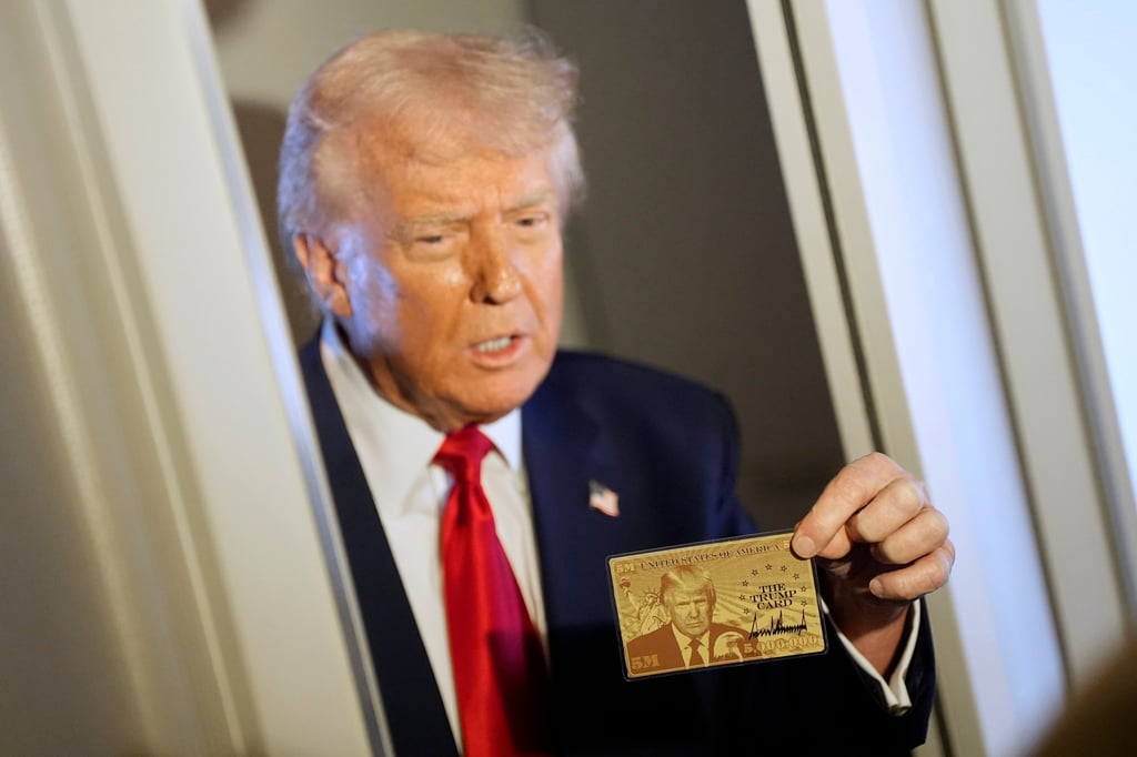 US President Donald Trump holds up the “Trump Gold Card” on board Air Force One. The card offers residency and a path to citizenship to investors who pay US$5 million. Photo: AP