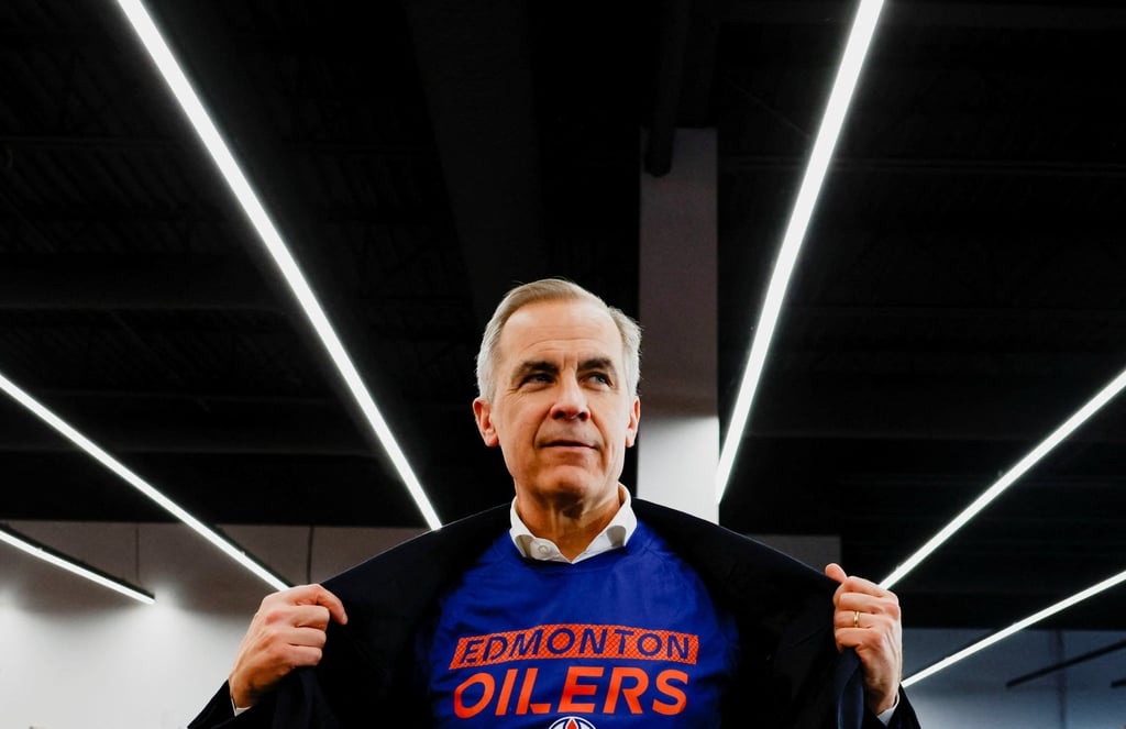 Canada’s Prime Minister Mark Carney shows his Edmonton Oilers’ T-shirt. Photo: Reuters