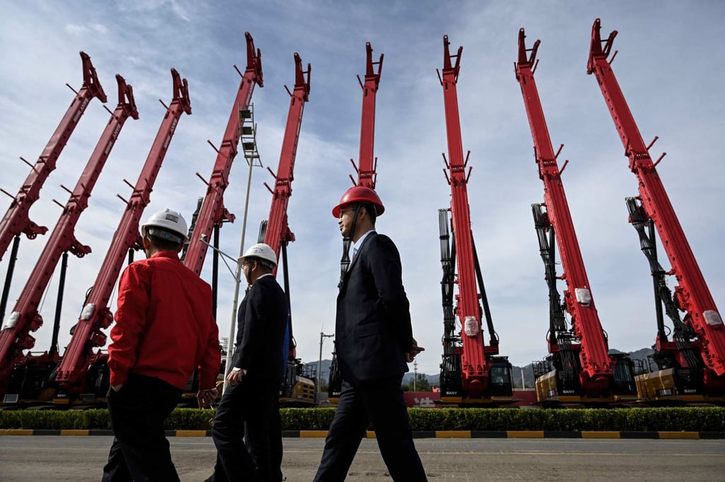 People walk past cranes made by Sany at a factory in Beijing in October 2021. Photo: AFP