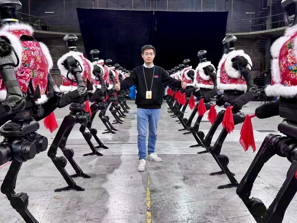 Wang Xingxing, founder and chief executive of Unitree Robotics, poses with the company’s H1 general-purpose humanoid robots that performed Chinese folk dance Yanggea during the annual Spring Festival Gala show in January. Photo: Weibo