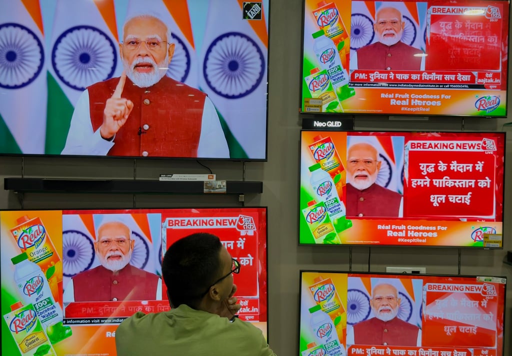 A man watches the live telecast of Indian Prime Minister Narendra Modi’s speech on television screens in Prayagraj, Uttar Pradesh, India, on Monday. Photo: AP