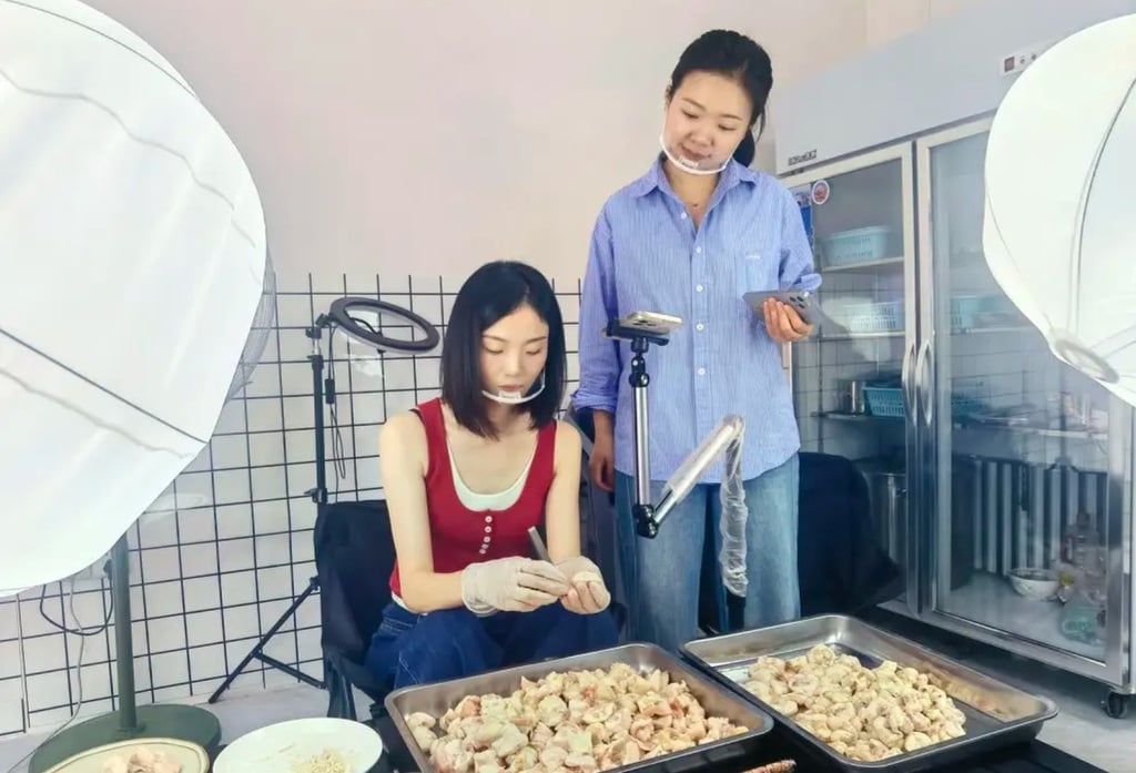 Wang Yuxian, left, carefully plucks away at piles of chicken pieces during a live-stream. Photo: QQ.com