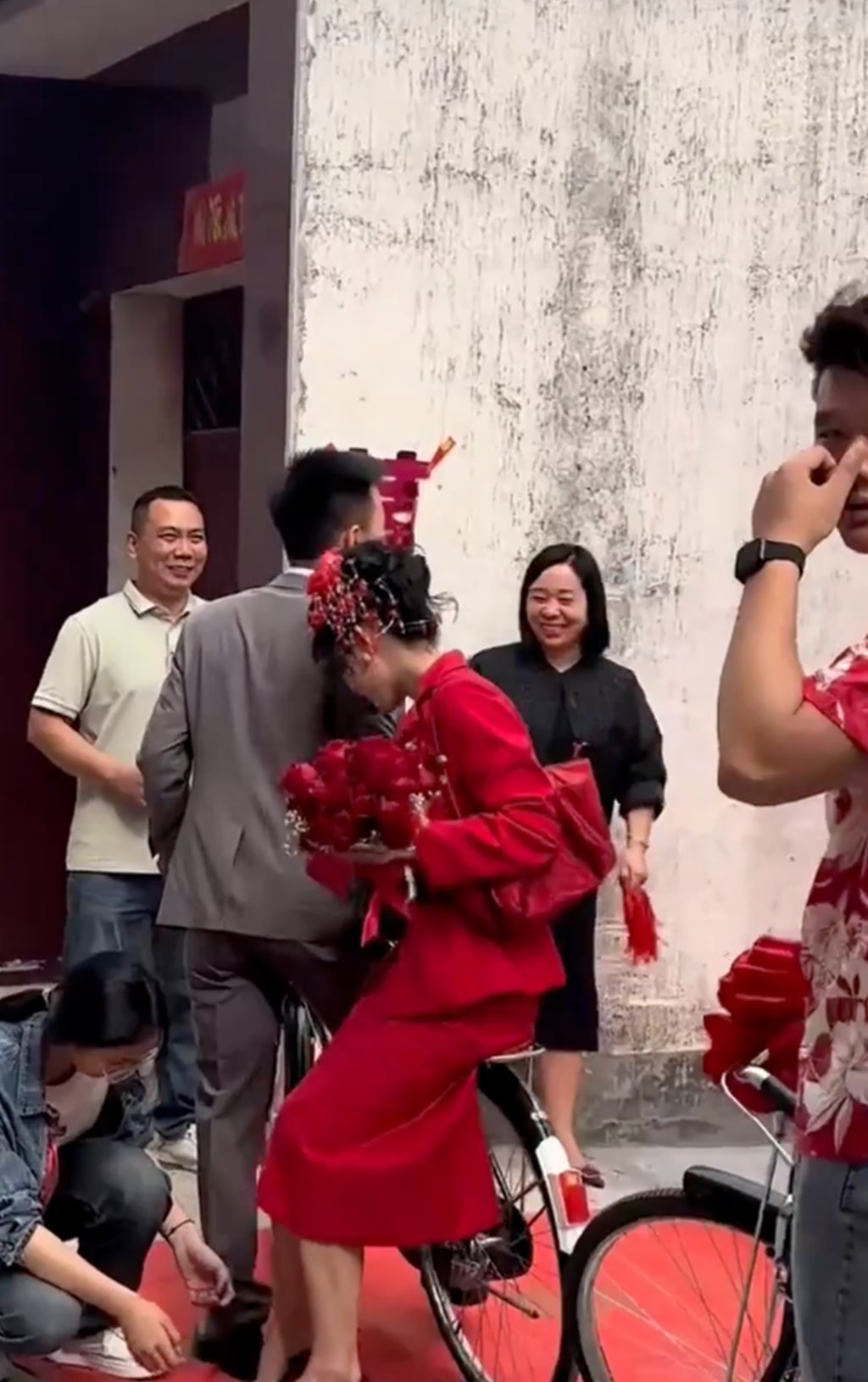 The bride dismounts the traditional-style bicycle onto a red carpet at the end of the journey. Photo: thepaper.cn