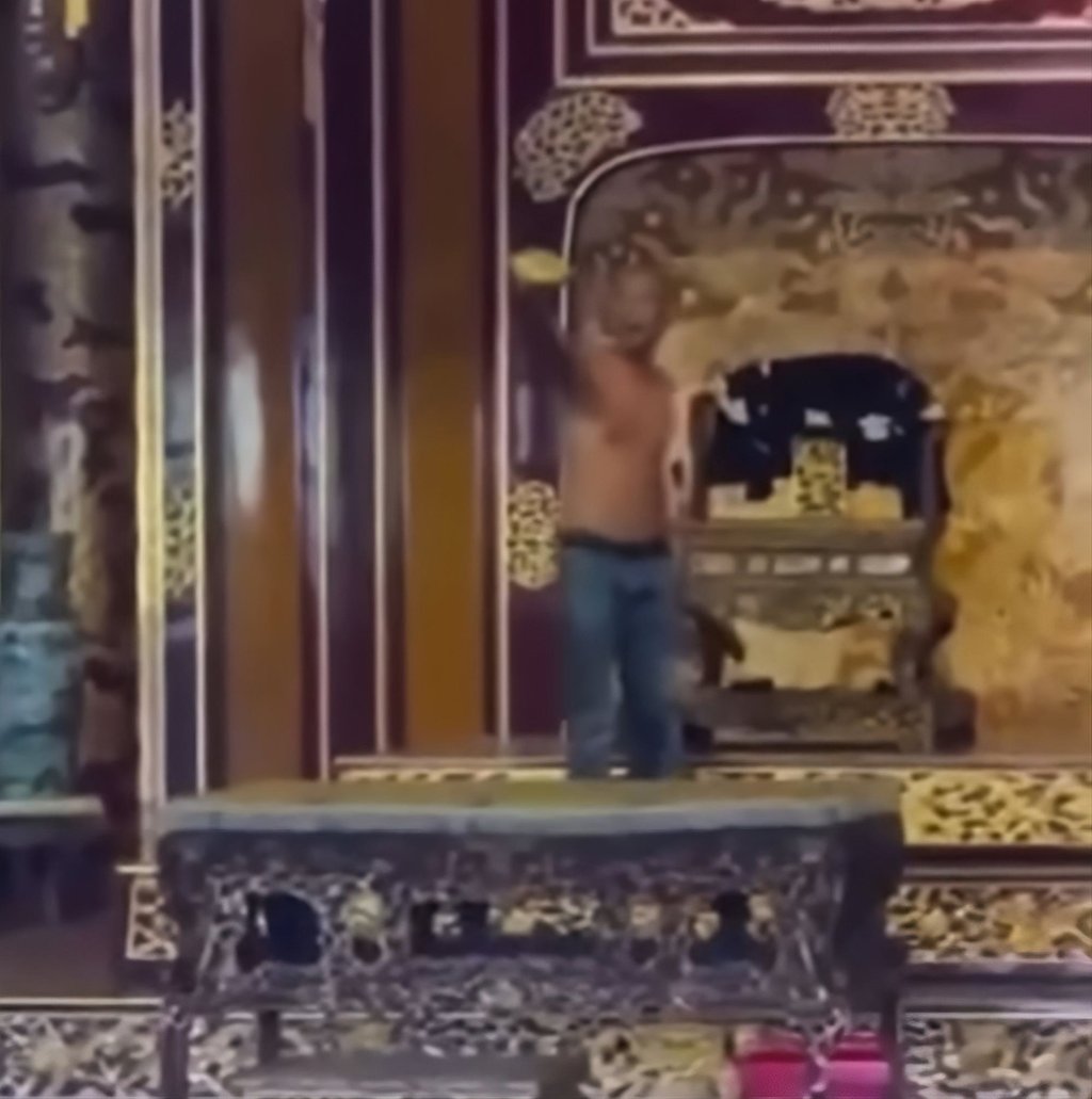 A still image from a video circulated on social media shows a shirtless man in the throne room of Hue city’s Thai Hoa Palace. Photo: Facebook/MaiThanhMai