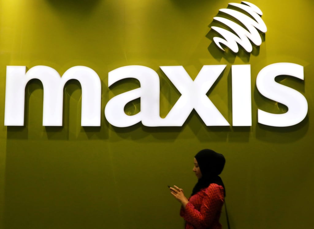 A woman walks past a logo of Maxis at its headquarters in Kuala Lumpur. The mobile network operator has already submitted a full report with anonymous data. Photo: Reuters