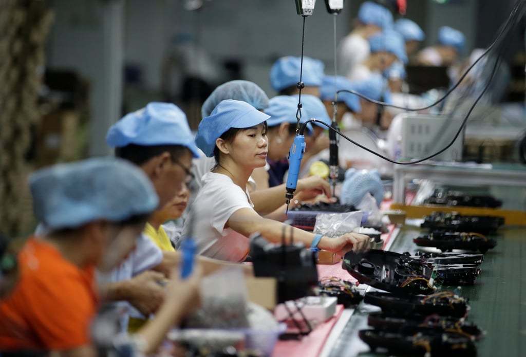 Employees work on the production line of a robot vacuum cleaner factory in Shenzhen, August 9, 2019. Photo: Reuters