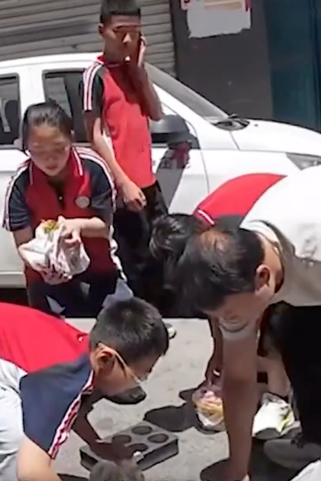 The eager, helpful youngsters set about picking up the delivery driver’s spilled cargo. Photo: handout