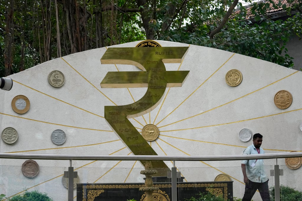 A man walks past the rupee symbol outside the Reserve Bank of India headquarters in Mumbai on June 6. The central bank last week delivered a larger-than-expected interest rate cut of 50 basis points. Photo: AP