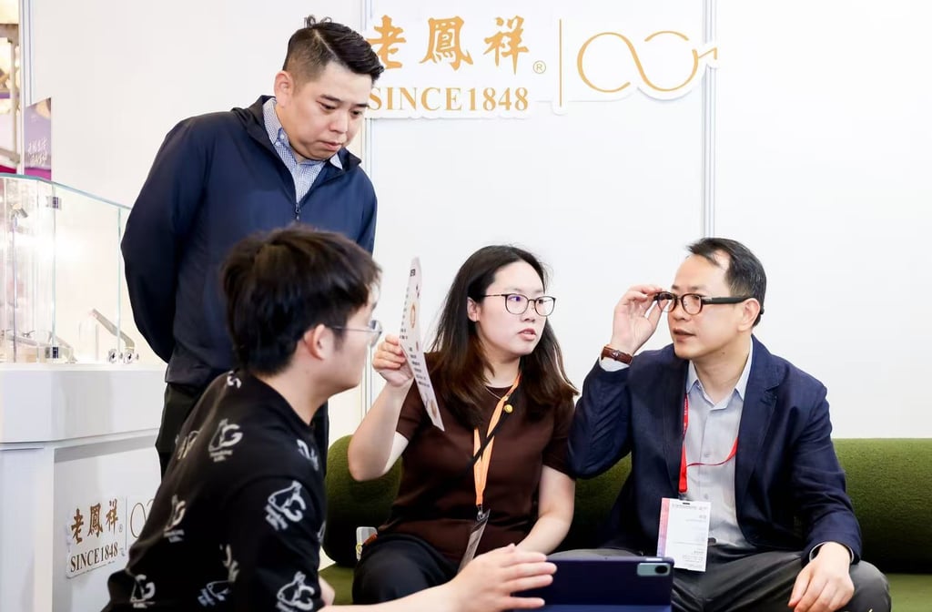 Lao Feng Xiang chairman Yang Yi, right, tries on a pair of the company’s new line of smart glasses powered by ByteDance’s artificial intelligence technology. Photo: Handout