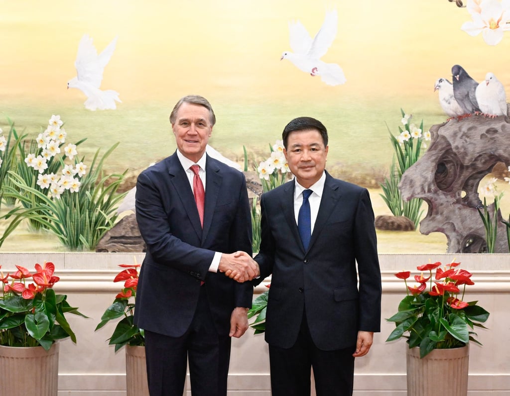 China’s Minister of Public Security Wang Xiaohong (right) shakes hands with US ambassador to China David Perdue (left) in Beijing on Thursday. Photo: EPA-EFE/Xinhua