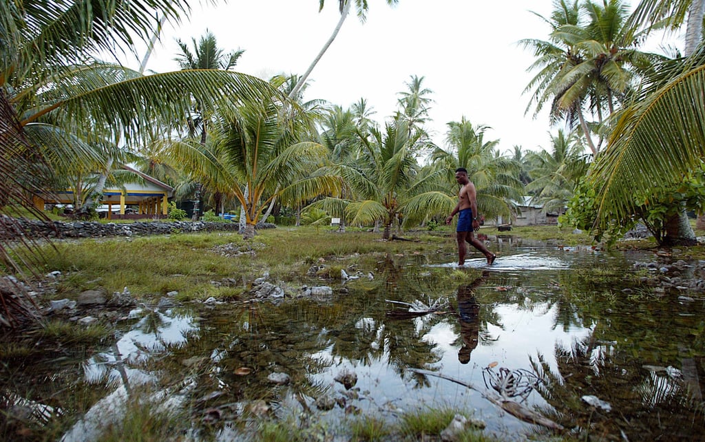 Water welling from the rocky ground forms a new lake in the centre of Amatuku Islet of Funafuti, Tuvalu. About 3,125 Tuvaluans have applied for a climate visa to live in Australia. Photo: AFP
