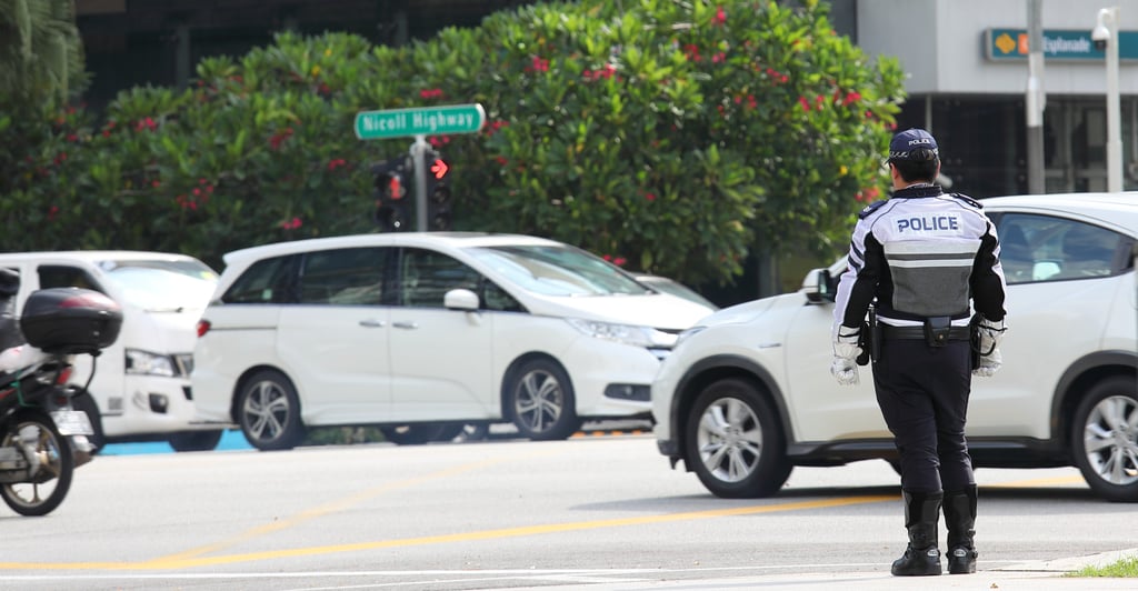 A police officer keeps an eye on downtown traffic in Singapore. Photo: Shutterstock