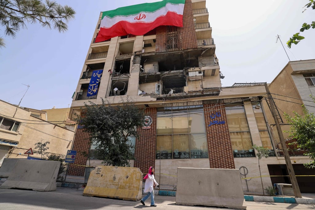 A woman walks past a damaged building in Tehran, Iran, on Wednesday following Israeli strikes on the city. Photo: AFP