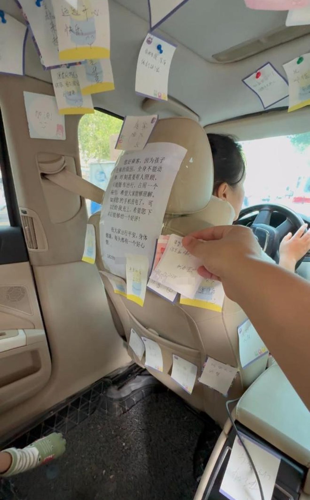 A passenger sticks a supportive note on the back of Zhang’s driver seat. Photo: Handout