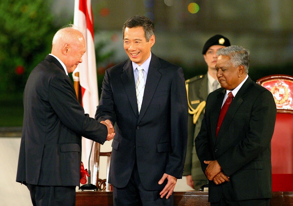 Singaporean Prime Minister Lee Hsien Loong, centre, shakes hands with his father, Minister Mentor Lee Kuan Yew, while standing next to President S.R. Nathan, right, on August. 12, 2004. Photo: AP