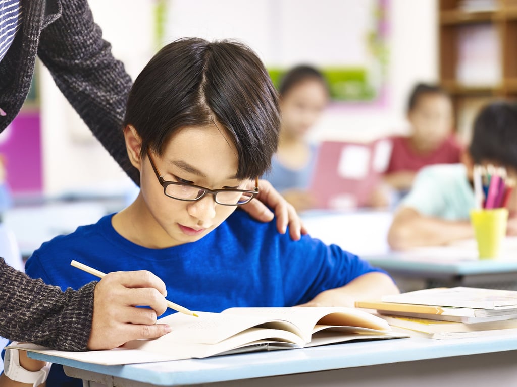 A pupil gets help from teacher in class. One of the most forceful condemnations of the proposed drama came from South Korea’s largest teaching union. Photo: Shutterstock