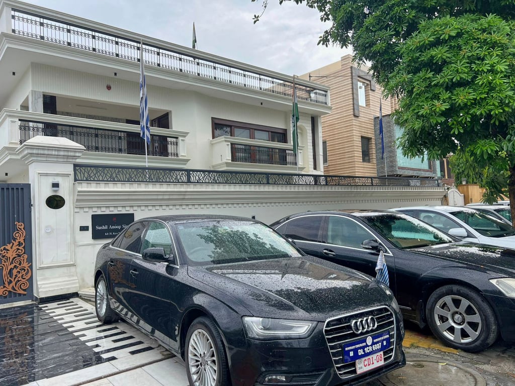 Luxury cars bearing fake diplomatic number plates parked outside a rented residential building in which a bogus embassy was operating in Ghaziabad, India. Photo: AP
