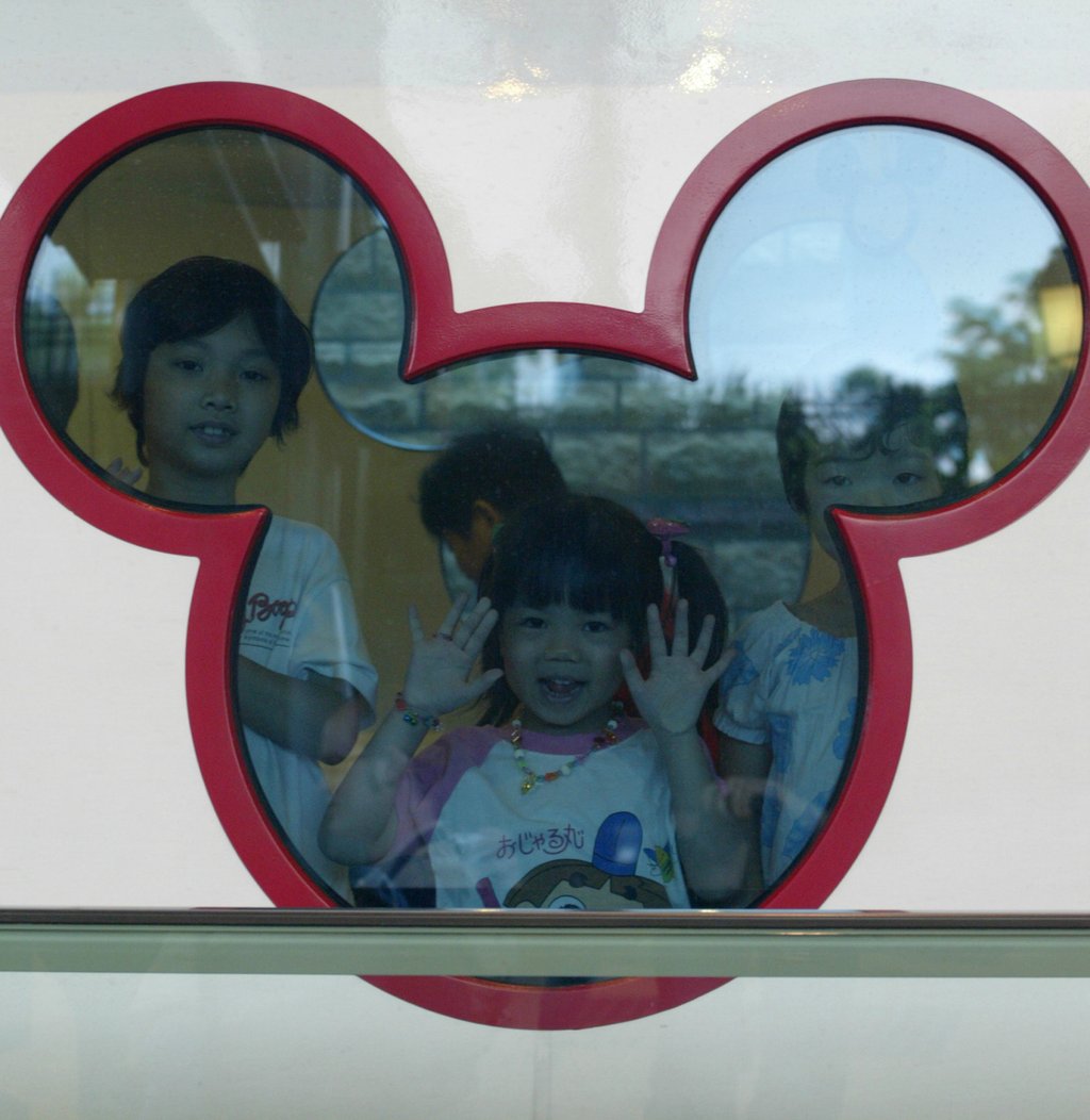 Children excitedly look through a Mickey Mouse-shaped window on a Disneyland Resort line train on August 1, 2005. Photo: Dustin Shum