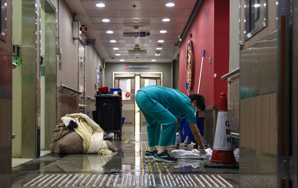 A member of staff dries the floor at Queen Mary Hospital in Pok Fu Lam. Photo: Karma Lo