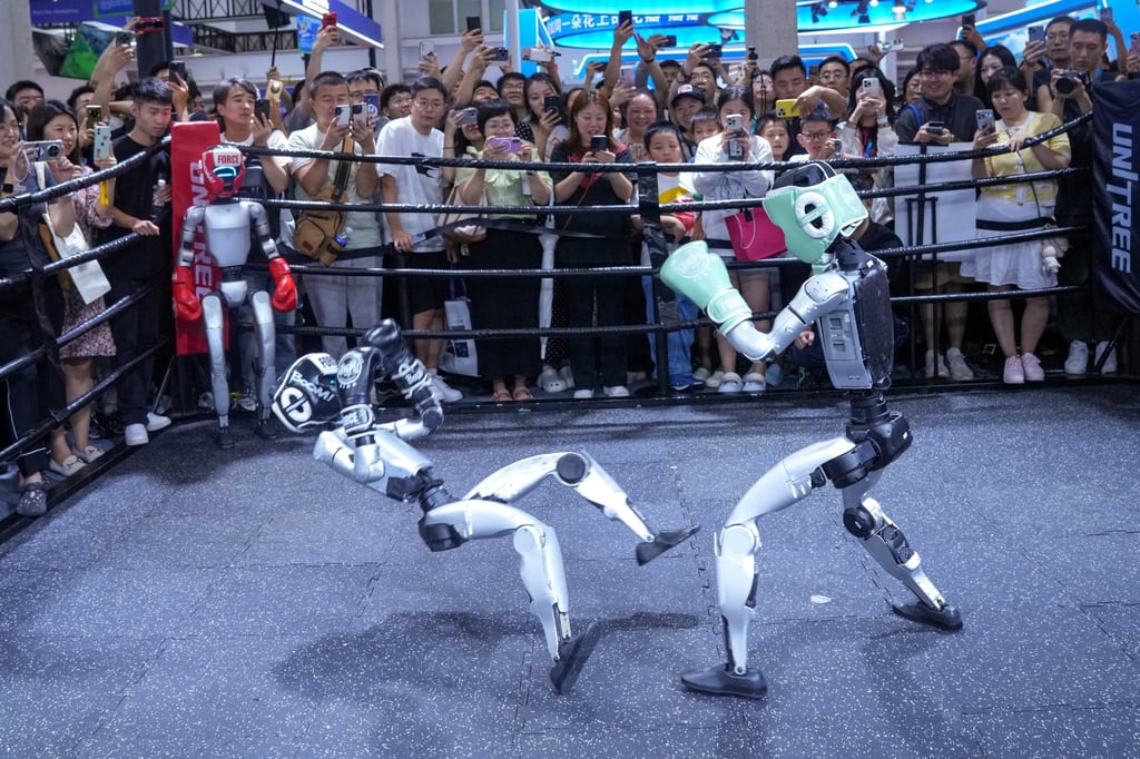 Visitors watch humanoid robots fight at the Unitree booth during the World Robot Conference in Beijing. Photo: cnsphoto via Reuters