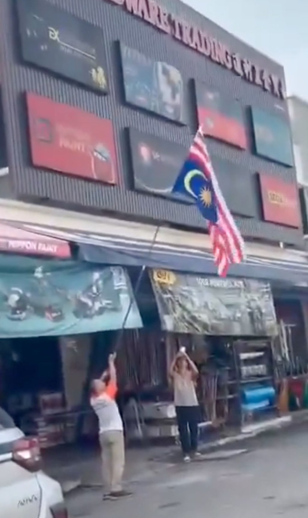 An ethnic Chinese trader accidentally hoists the national flag upside down in front of his hardware shop in Penang on Saturday. Photo: Handout