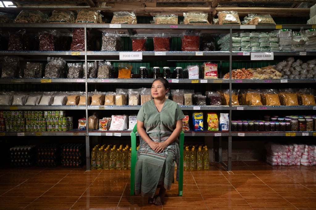 Naw Wah Nay Paw, 40, sits before shelves of food at her shop in Mae La Camp on July 31. Photo: Janelle Ling